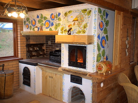 Interior view of an oven complex with a mini pizza oven, grill, cooking plate, and Petrykivka-style decoration